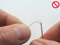 Avec des fils métallisés, éviter d'enfiler le bout du fil dans l'aiguille.